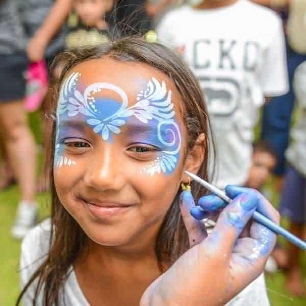 A face painter at work creating a colorful design for a child